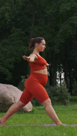 mujer embarazada practicando yoga en un parque