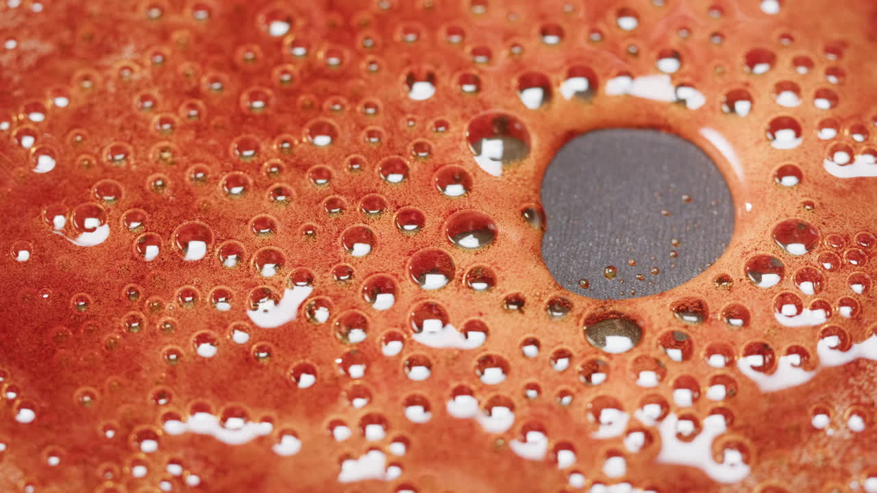 Close-up view of a red liquid with bubbles