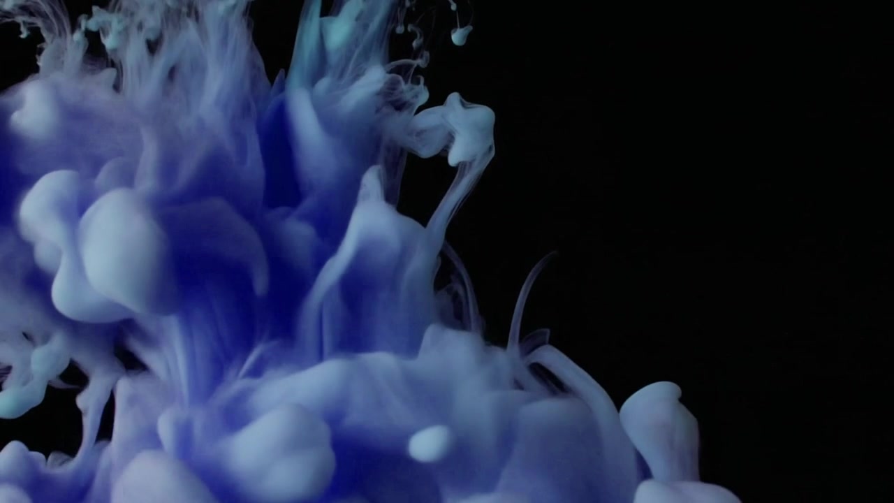Inchiostro blu che cade e si avvolge nell'acqua su sfondo nero