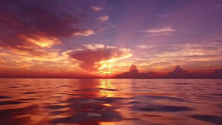 Serene Sunset Over Calm Waters: A Breathtaking View of Vibrant Colors Reflecting in the Ocean as the Day Transitions into Night, Capturing Nature's Majesty