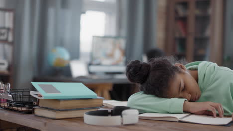 afro girl sleeping at desk at home