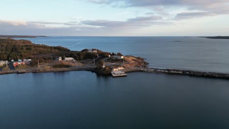 un vuelo sobre la bahía de mira desde la isla de scatarie, volando hacia una pequeña ciudad sobre el océano