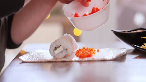 hacer sushi en la cocina de casa. manos de mujer enrollando sushi casero.