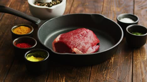 bowls with spices near uncooked meat