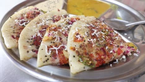 un vendedor de comida callejera sirve uttapam en su puesto de comida callejera en varanasi, india, el 7 de marzo de 2021
