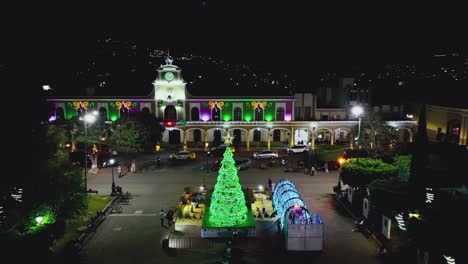 árbol de navidad iluminado por la noche en la plaza del pueblo frente al ayuntamiento de ciudad guzman, méxico