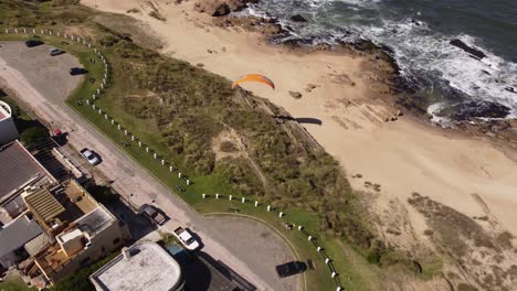 Turista-Disfrutando-Del-Parapente-Desde-Los-Acantilados-Junto-A-La-Playa-En-El-Pueblo-De-La-Pedrera-En-La-Costa-Atlántica,-Uruguay