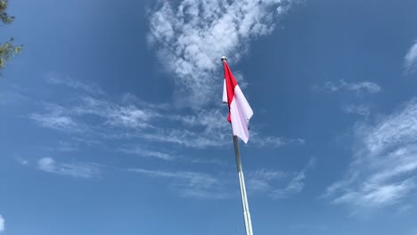 Bandera-Indonesia-Ondeando-En-Un-Poste-Alto-Contra-Un-Hermoso-Cielo-Azul