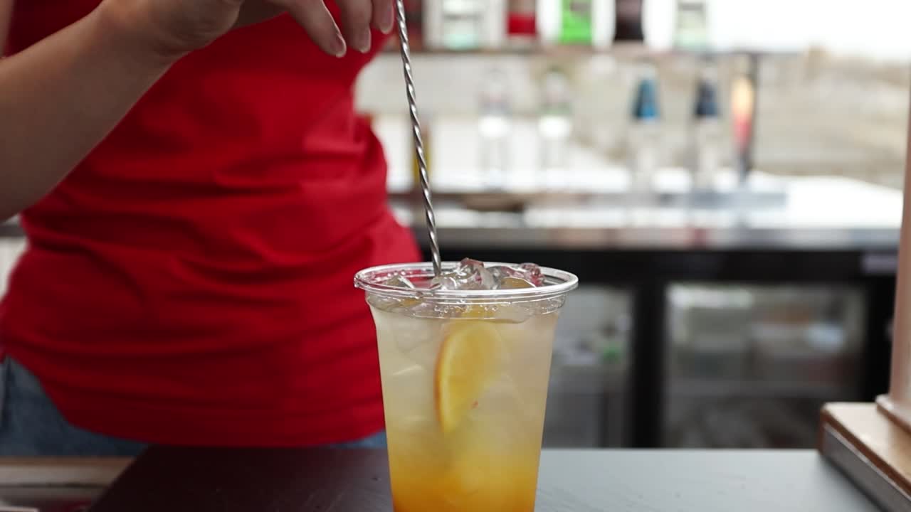 바텐더 가 오렌지 맛 의 상쾌 한 음료 를 만들고 있다