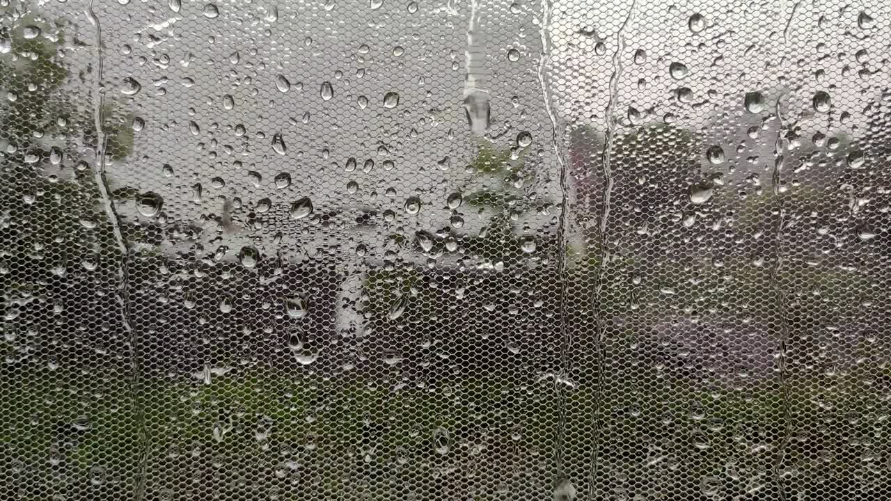 Real rain drops sliding on home window glass. Heavy rain. Close-up of water droplets on glass.