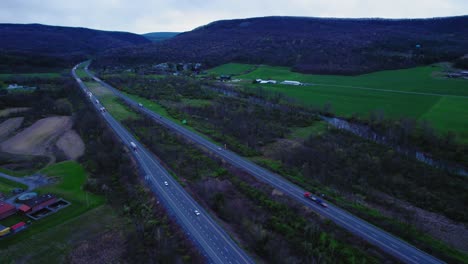 Overhead-view-of-Interstate-Highway-in-Pennsylvania-illustrating-the-logistics-of-semi-trucks-and-cars-traversing-through-a-rural-landscape