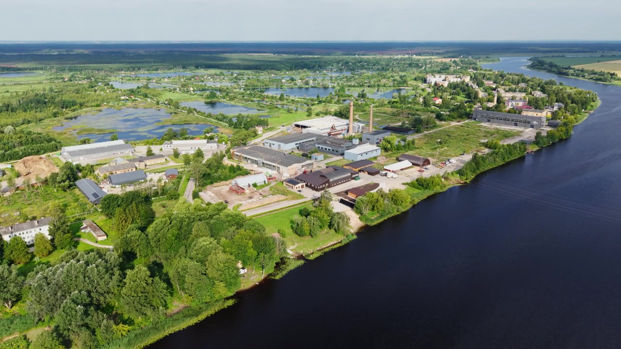 Dron delikatnie zbliża się do kompleksu produkcyjnego Kalnciems nad rzeką Lielupe