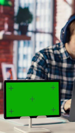 vertical video mockup tablet next to worker in home office wearing headphones editing documents