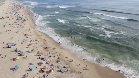 Drone-view-of-tourists-on-the-beach-in-El-Tabo,-Chile