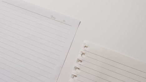 video of close up of four sheets of notebook paper on white background