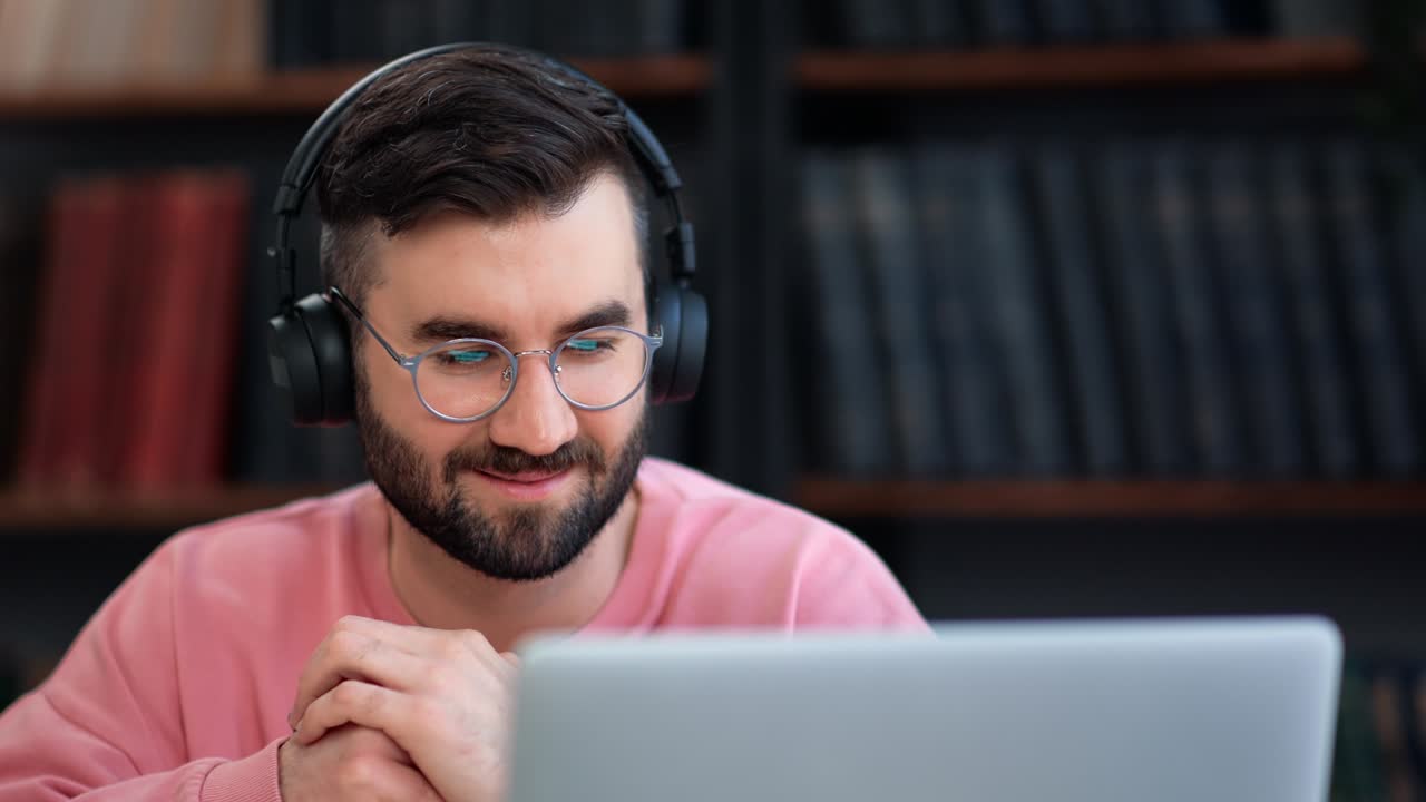 Closeup male headphones talking online video call use laptop consulting remotely working at library