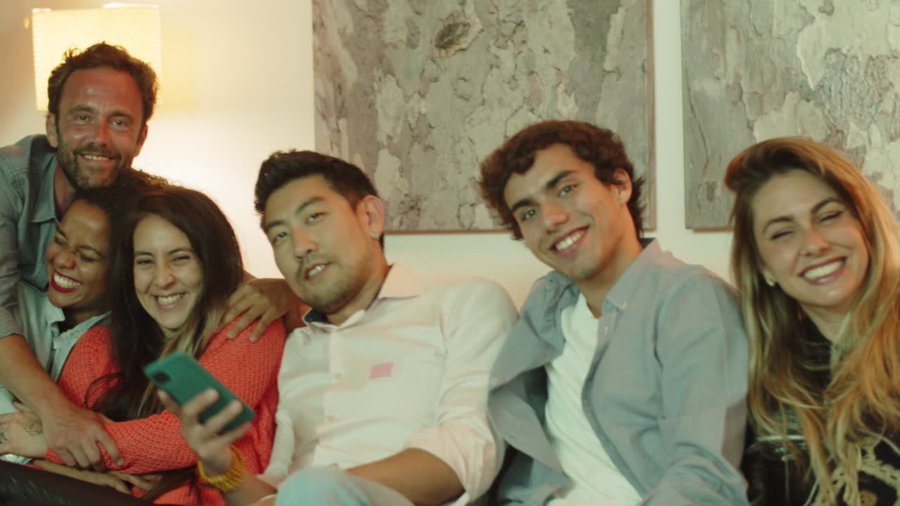 소파에 앉아 안고 있는 행복한 친구들의 슬라이더