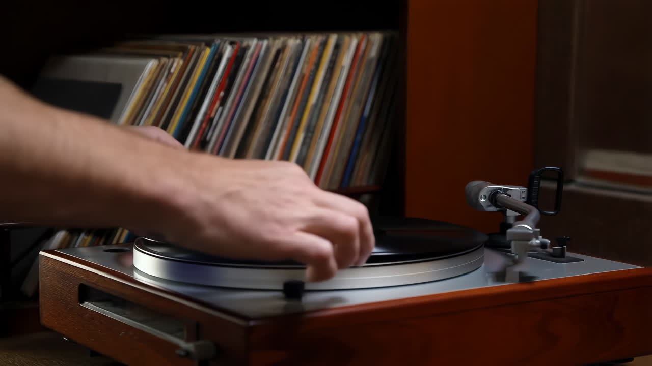 Person selecting and placing a vinyl record on a turntable
