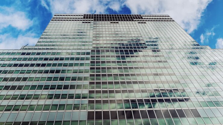 Ventanas de cristal del edificio reflejando nubes que se mueven rápidamente