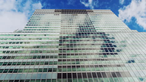 ventanas de vidrio del edificio que reflejan nubes que se mueven rápidamente