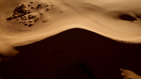 an overhead drone shot shows a canvas of pink sand and abstract shapes in utah’s southern desert.