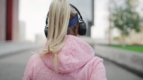 vista posteriore di una donna che fa jogging in città