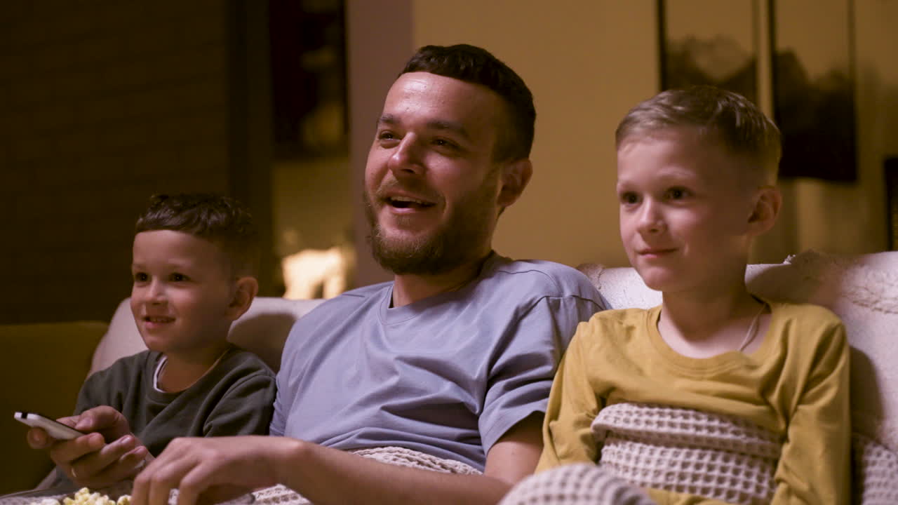 Father and sons watching funny movie