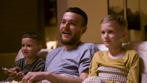 father and sons watching funny movie