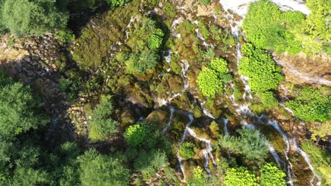 Cascada-En-La-Ladera-De-La-Montaña-Que-Cae-Sobre-Rocas,-Vista-Aérea-De-Arriba-Hacia-Abajo