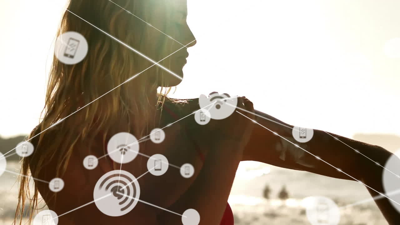 On beach, person with animation of digital network icons overlaying silhouette