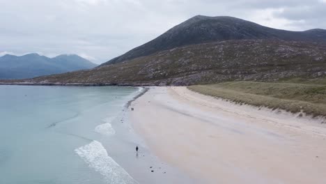 tiro de dron inclinado de la playa de luskentire en un día soleado de verano, con gente visible caminando por la arena