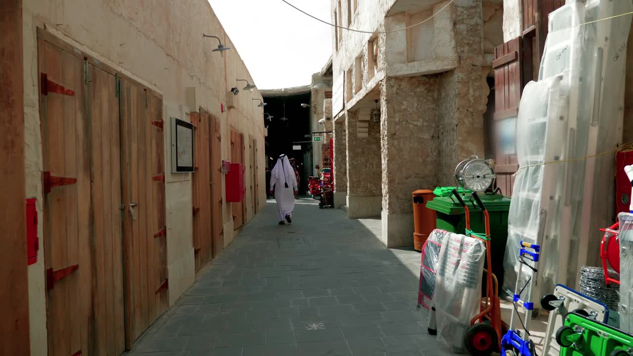 아라비아 의 옷 을 입은 남자 가 중동 의 소크 시장 거리 에서 고 있다