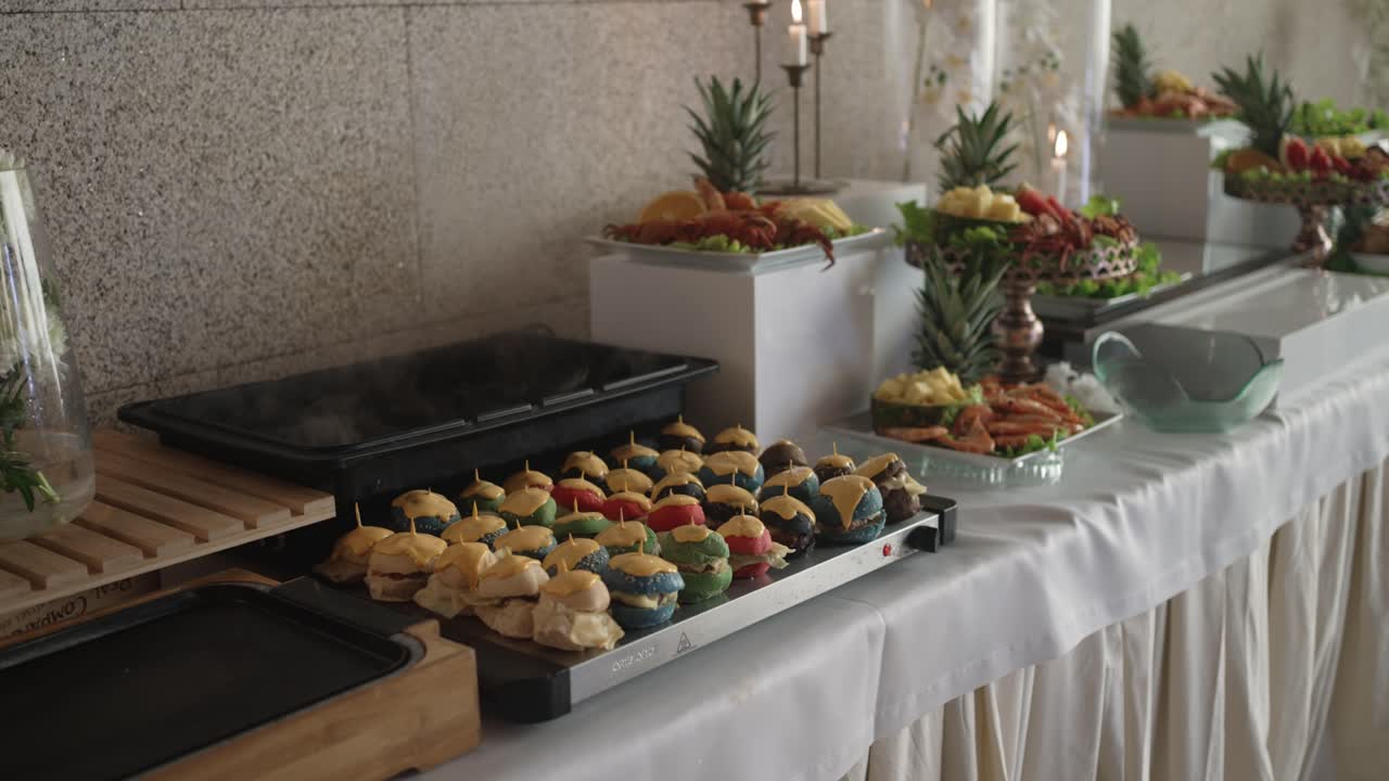 steaming buffet with assorted mini burgers and shrimp platters set for wedding reception