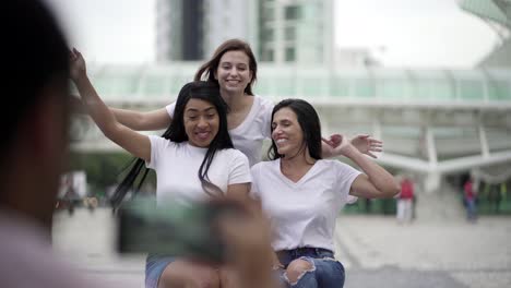 smiling women posing for photo while sitting on square