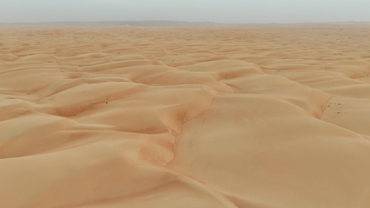 Aerial drone view of Azouiega endless desert with soft curves, rippling patterns, dramatic sunlight Mauritania Sahara Desert