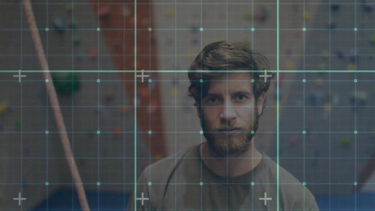 Climber standing at climbing wall in sports tech grid overlay shifting across torso simulating scan