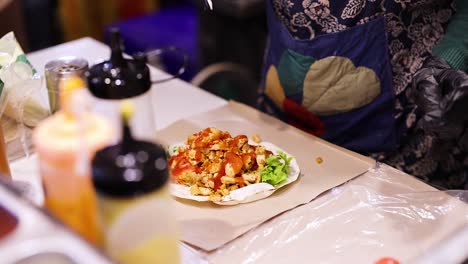vendedor montando kebab doner con salsas y ingredientes
