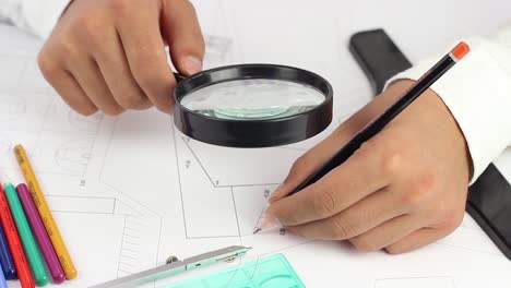 arquitecto chequea el proyecto con lupa