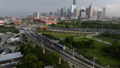 drone following the metro moving toward the downtown of houston, golden hour