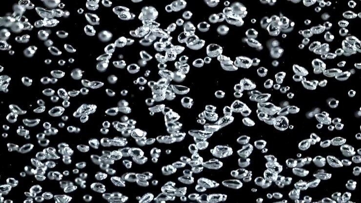 Numerose bolle d'aria limpide che fluttuano e risalgono su sfondo nero