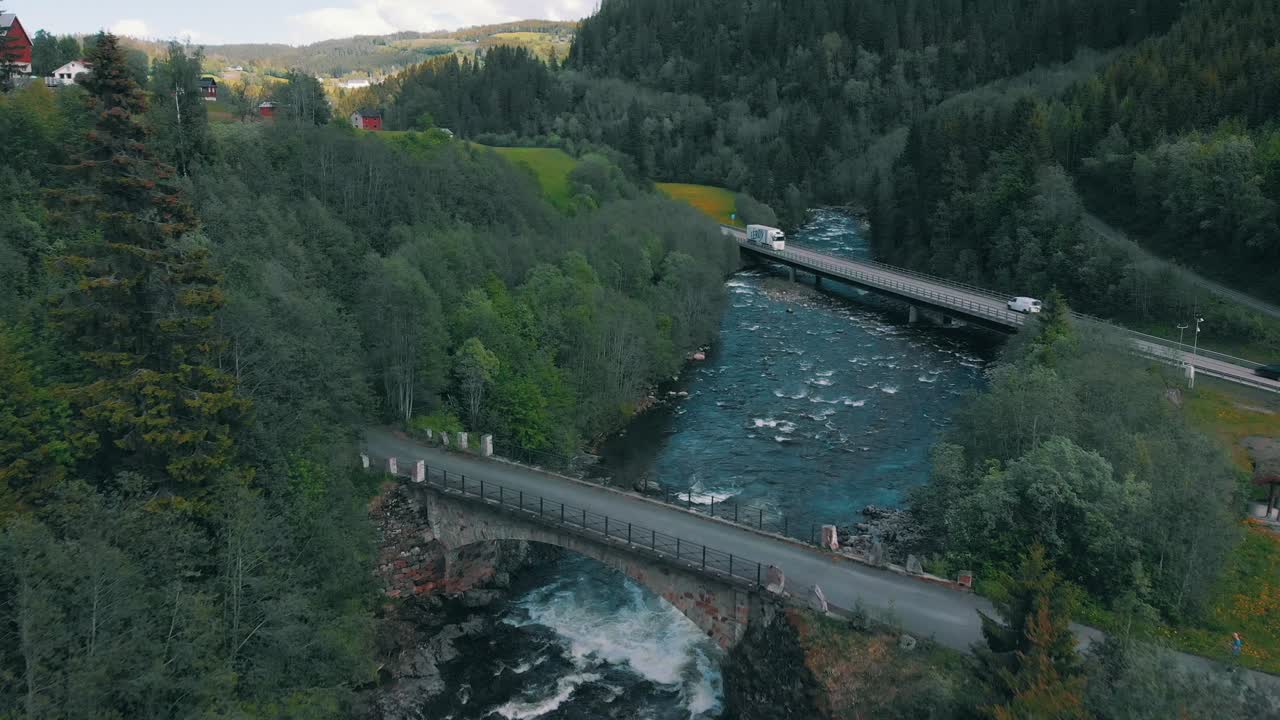 Drone footage of a beautiful river and two bridges with some traffic crossing