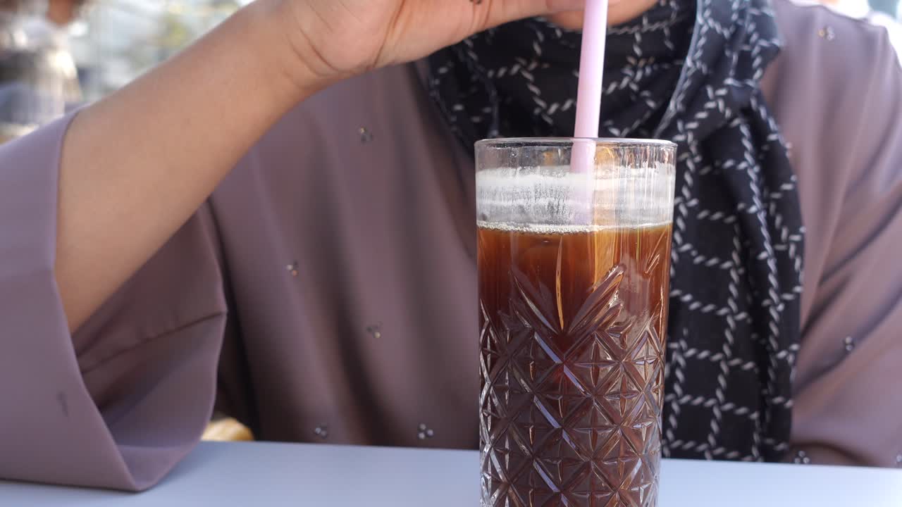 mujer bebiendo café helado al aire libre