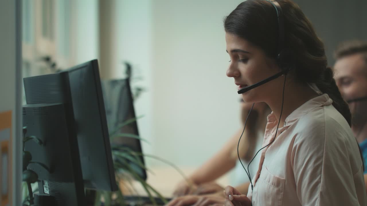 Call center operator talking with client. Pretty woman working at call centre.