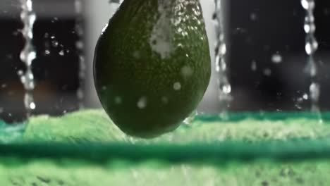 captivating close-up of an avocado being rinsed under water in a green mesh basket, showcasing its freshness and texture for culinary inspiration