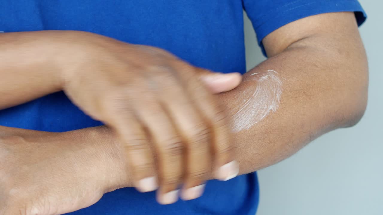 hombre aplicando loción en su brazo