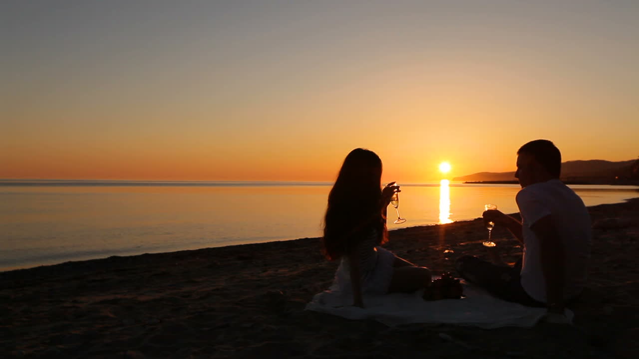 Couple on beach at sunset. Young couple spending time together at sunset on beach