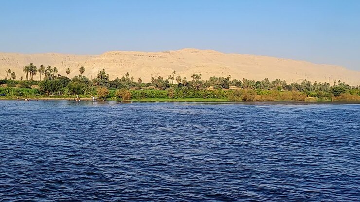 Banks of the Nile with vegetation and desert mountains in the background