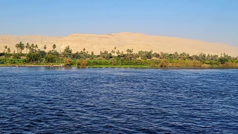 banks of the nile with vegetation and desert mountains in the background