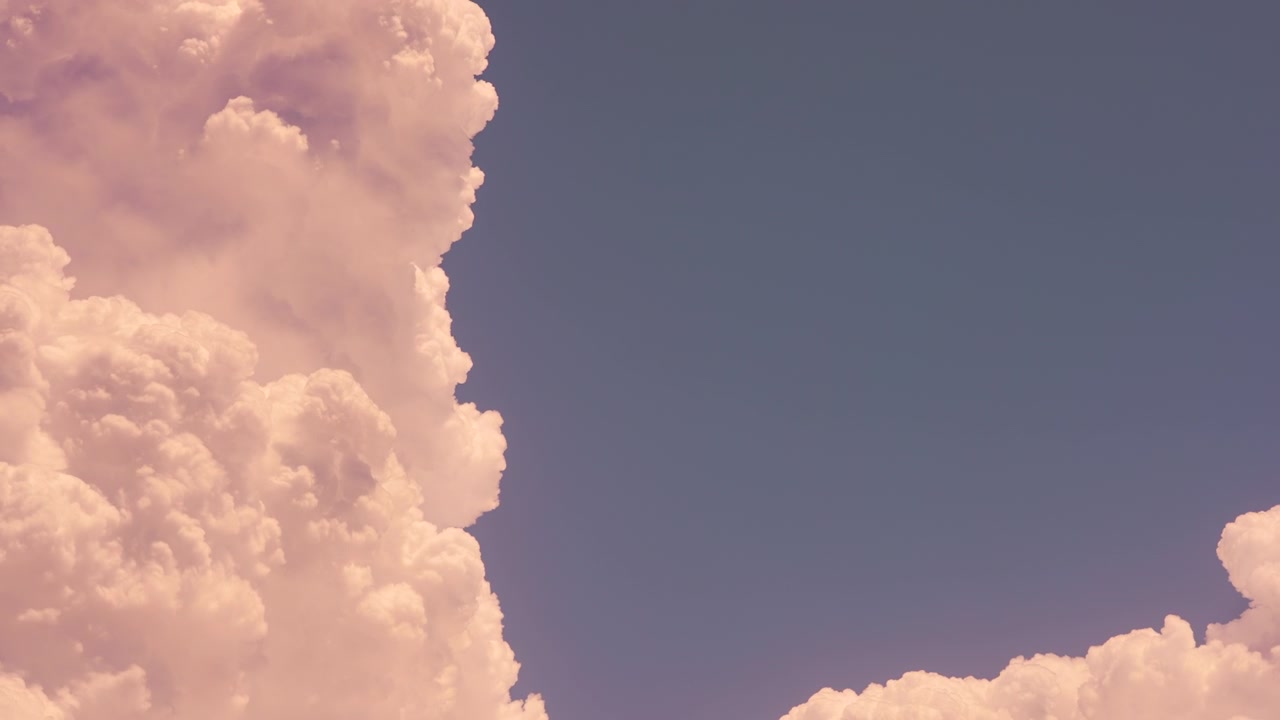 Large White Cumulus Clouds Moving Across a Clear Blue Sky