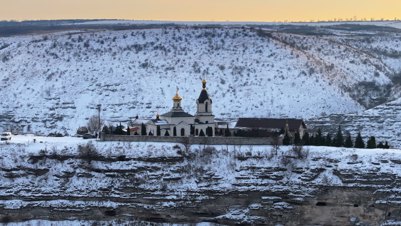 Aerial drone view of the Old Orhei covered in snow at sunrise. Monastery located on a hill in Moldova